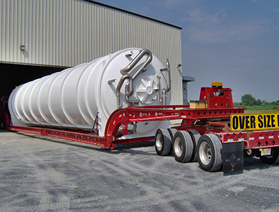 An oversize load trailer hauling a large vessel into the blasting and liquid coating facility