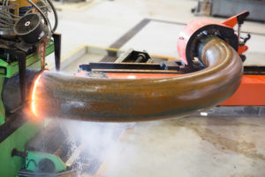 Heat induction bender bending a steel pipe